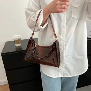 Close-up of a brown translucent PVC underarm bag with decorative chain link