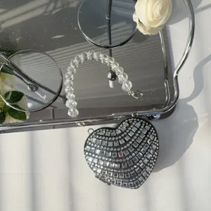 Detail view of a luxury heart-shaped mini evening bag with sparkling rhinestones and beads