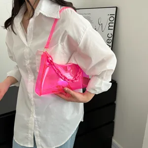 Lifestyle shot of a vibrant pink transparent PVC chain underarm jelly bag.