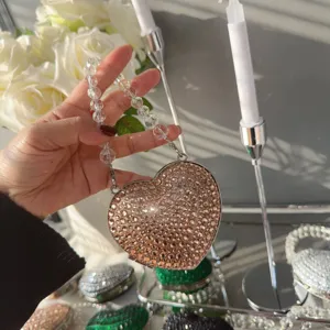 Macro detail of luxury heart-shaped evening bag featuring sparkling champagne rhinestones