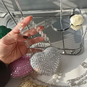 Close-up of heart-shaped mini evening bag covered in shimmering silver rhinestones