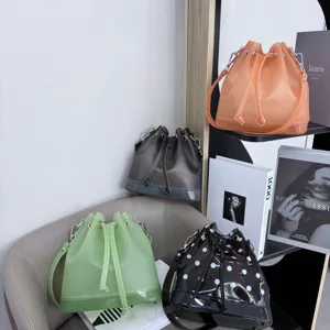 Fashionable frosted TPU jelly bucket bag with drawstring closure and shoulder strap.