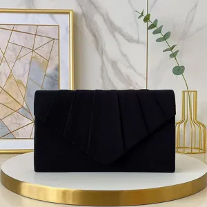 Elegant black pleated envelope evening clutch bag with a matte texture on a marble base