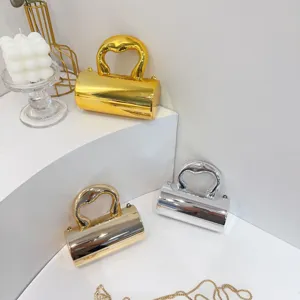 Close-up of three mini metallic evening bags in gold, silver, and champagne gold finishes.