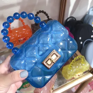 Mini blue transparent jelly bag with quilted pattern and unique beaded handle detail.