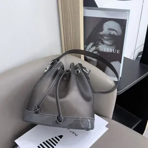 Detail view of a frosted gray TPU jelly bucket bag with drawstring closure in a modern setting