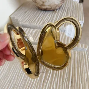 Detailed close-up of heart-shaped gold evening clutch showing internal structure