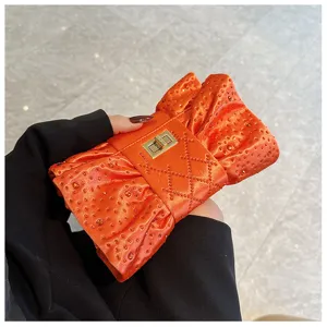 Vue détaillée de la pochette de soirée luxe en strass orange avec fermoir doré tournant