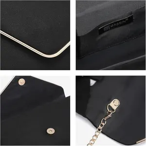 Detail view of black evening clutch with gold metal edging and fine chain strap