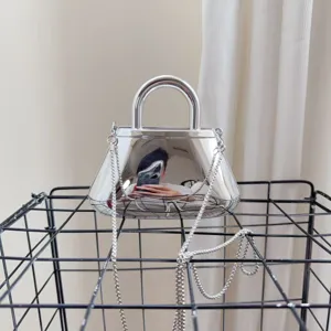 Primo piano di una borsa da sera in acrilico a specchio argento con tracolla a catena