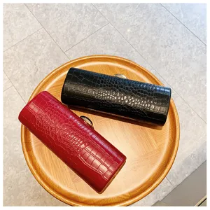 Detailed macro view showing the texture of black and red crocodile pattern clutch bags