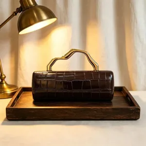 Close-up of vintage brown PU crocodile pattern evening clutch with gold handle