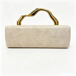 Close-up of elegant cream crocodile-patterned clutch bag with wavy gold handle