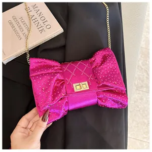 Magnifique pochette en velours fuchsia avec nœud et détails de strass brillants