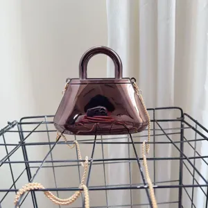 Dettaglio della borsa da sera in acrilico riflettente con elegante catena dorata