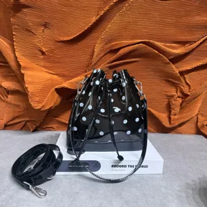 Detailed view of black polka dot TPU bucket bag with drawstring on a prop book