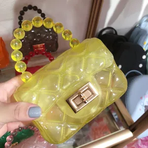 Close-up of yellow transparent diamond quilted mini jelly bag featuring a beaded handle