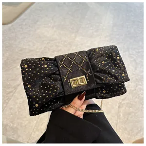 Pochette de soirée élégante et étincelante en velours noir avec strass dorés à nœud.
