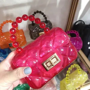 Detailed view of a bright pink mini quilted jelly bag with a stylish red bead handle