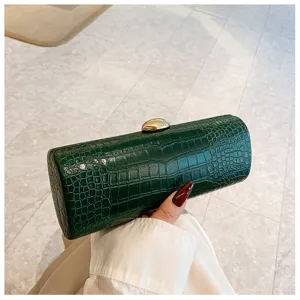 A detailed view of this elegant green crocodile pattern baguette clutch with a gold clasp