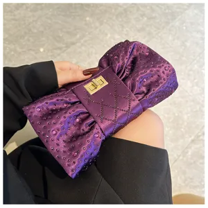 Vue détaillée d'une pochette de soirée violette en forme de nœud à strass scintillants