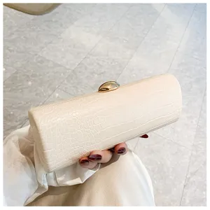 Detail of cream retro crocodile pattern baguette clutch bag with gold oval clasp