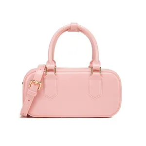 Vista dettagliata di una borsa rettangolare rosa lucida con fibbia dorata.