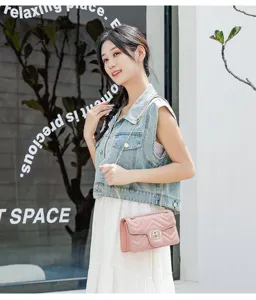 Chic pink chevron quilted leather crossbody bag with gold chain strap shown on model