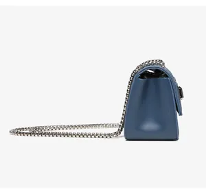 Vista laterale professionale della borsa a tracolla in pelle blu con catena argento