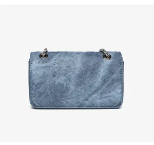 Vista posteriore dettagliata di una piccola borsa quadrata in denim trapuntato con catena