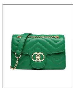 Detailed view of a green quilted crossbody bag with gold chain and circular clasp