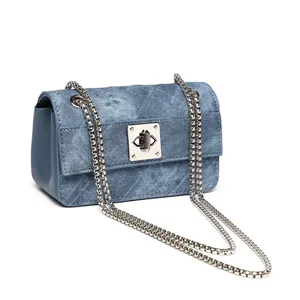 Piccola borsa quadrata in denim retrò con tracolla a catena d'argento e chiusura in metallo.