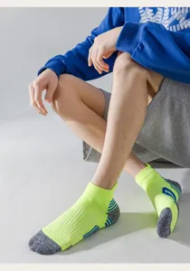 Close-up view of neon green athletic socks with grey towel sole for men running training.