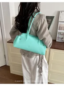 Close-up detail of a mint green PVC jelly baguette tote bag worn as a shoulder bag
