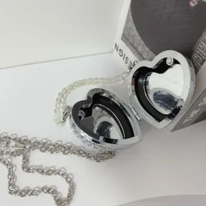Interior detail view of the heart-shaped rhinestone lipstick bag featuring dual mirrors