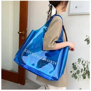 Stylish blue transparent PVC jelly tote bag with bold lettering carried by a model