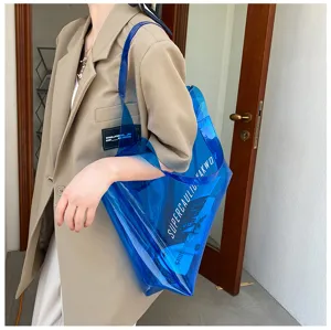 Close-up detail of blue transparent PVC jelly tote bag with white lettering