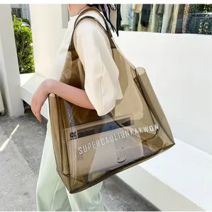 Detailed view of a large brown transparent PVC jelly tote bag with white letter print