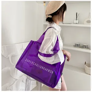 Detail showing a large purple transparent PVC jelly tote bag with white letter print.