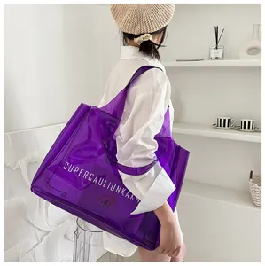 Detail view of the transparent purple PVC jelly tote bag featuring bold white lettering