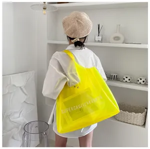 Large yellow transparent PVC jelly tote bag shown being carried in a lifestyle setting