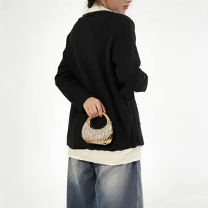 Elegant gold crescent shaped handbag with sparkling crystal embellishments held by a model