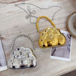 Détail de mini sacs de soirée en forme de nuage or et argent avec anses en perles métal.