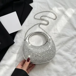Close-up of elegant silver rhinestone handbag with circular handle and chain strap