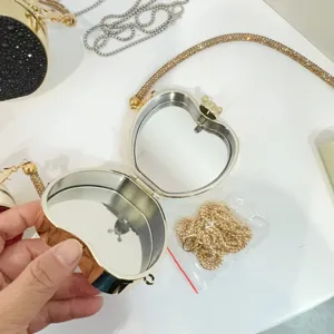 Vista dettagliata della mini pochette dorata a forma di cuore con specchio interno