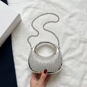Bolso de mano minimalista en metal plateado con cristales brillantes y cadena larga