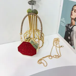 Elegante clutch da sera esagonale con strass rossi, manico dorato e catenella