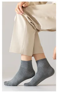 Gros plan détaillé de chaussettes grises en coton côtelé sur le pied, texture du tissu visible.