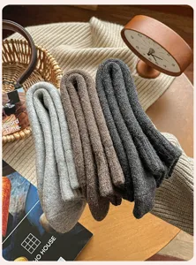 Detalle de calcetines de invierno de tubo medio de mezcla de lana, textura de punto, tres colores.