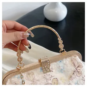 Detailansicht der Schmetterlingsstickerei und des Strassverschlusses der Abendtasche.